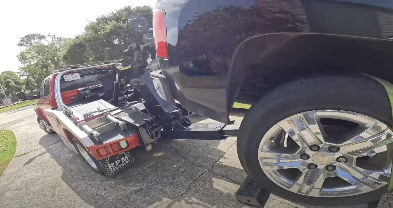 Wheel-lift tow truck close-up securing a vehicle for transport in Copiague, NY